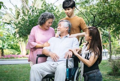 cheerful disabled grandfather in wheelchair welcoming his happy Family